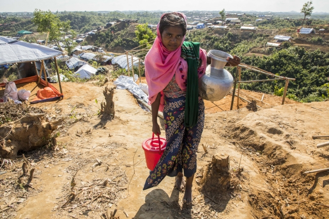水源のある谷から難民キャンプまで水汲みをする女の子
