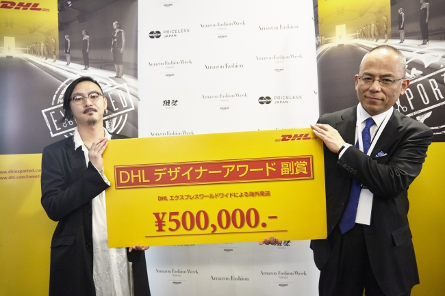 DHLジャパン 法人営業第五部長の吉本悟より第11回DHLデザイナーアワードを受け取る藤田哲平氏