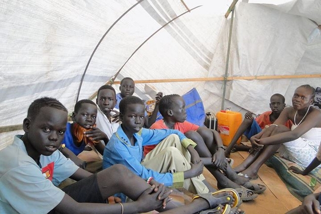 © UNICEF South Sudan/2014/Kolok　7歳から17歳までの兄弟8人の長男ニャンソンくん(17歳)。兵士である父親は兵舎に、母親は離れた村にいるため、子どもたちだけで、ジュバの難民キャンプで避難生活を送っています。「両親がいない暮らしは簡単ではありません。食料や調理用の炭の配給がもらえず、お腹を空かせていることもあります」(ニャンソンくん)