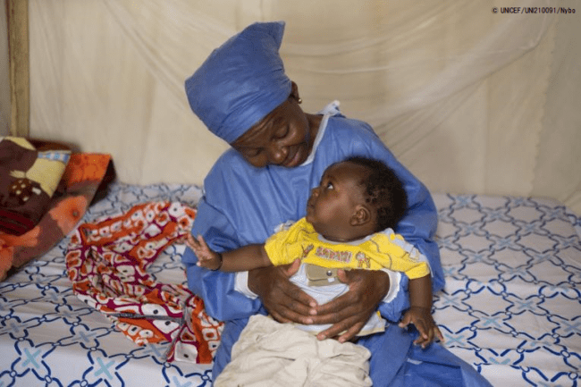 母親がエボラ出血熱の治療を受けている間、隣接する保育所で同じくエボラ出血熱の生存者であるスタッフに世話してもらう生後5カ月の男の子。(2019年9月撮影) © UNICEF_UNI210091_Nybo