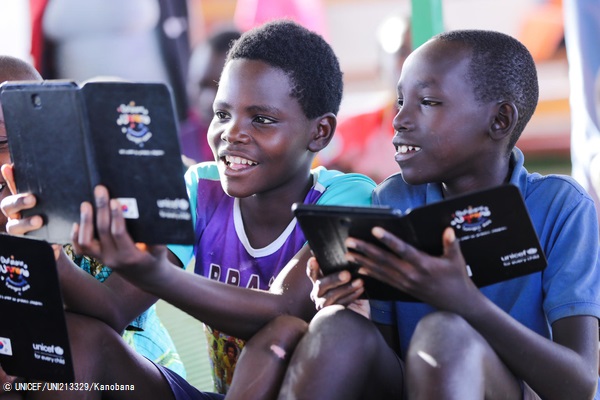 マハマ難民キャンプにある子どもにやさしい空間で、タブレットを用いたユニセフの学習プロジェクトの一環で教育アプリを使って遊ぶブルンジ難民の子どもたち。 (ルワンダ、2019年10月撮影) © UNICEF_UNI213329_Kanobana