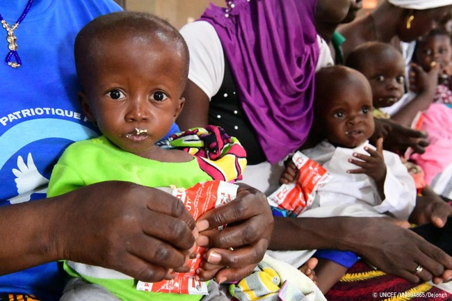 カヤの保健センターで、すぐに食べられる栄養治療食(RUTF)を口にする子どもたち。(ブルキナファソ、2020年10月2日撮影) © UNICEF_UNI394865_Dejongh