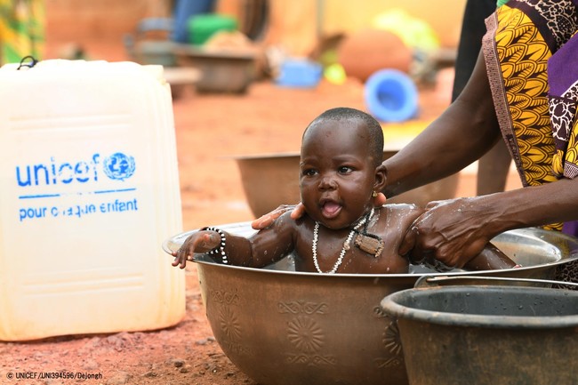 きれいな水で子どもの体を洗う女性。(ブルキナファソ、2020年10月3日撮影) © UNICEF_UNI394596_Dejongh