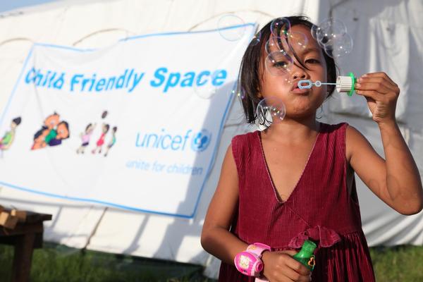 タクロバンに設置された「子どもにやさしい空間」の前で遊ぶ女の子。© UNICEF/NYHQ2014-0121/Giacomo Pirozzi
