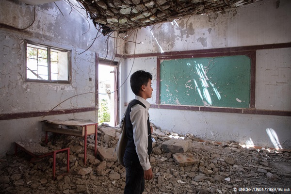 ハッジャ県にある爆撃で破壊された教室で、がれきの上に立つ12歳のアフメドくん。(イエメン、2021年3月撮影) © UNICEF_UN0472989_Marish