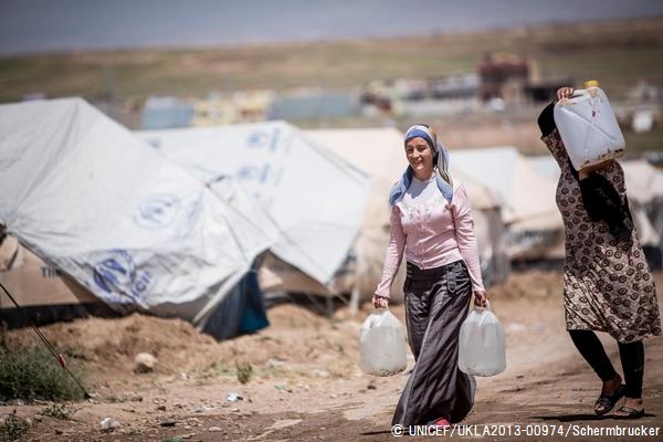 イラクの難民キャンプで、水を運ぶ女性　© UNICEF/UKLA2013-00974/Karin Schermbrucker