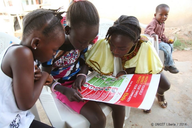 ユニセフは感染拡大を阻止するため、啓発活動に力を入れている。予防法のポスターを読む子どもたち。© UNICEF Liberia / 2014