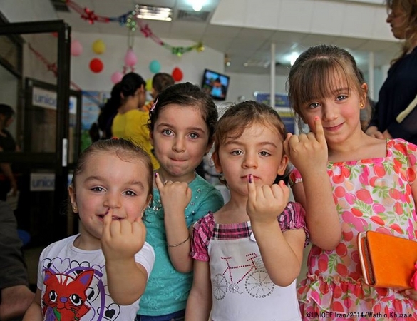 ポリオの予防接種を受けた子どもの指につけられる紫色の印を見せる子どもたち。©UNICEF Iraq/2014/Wathiq Khuzaie