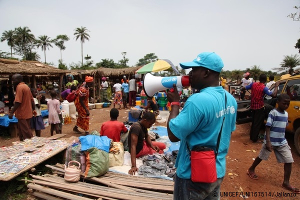 市場でエボラに関する重要なメッセージを伝える保健員。（リベリア）© UNICEF/UNI167514/Jallanzo