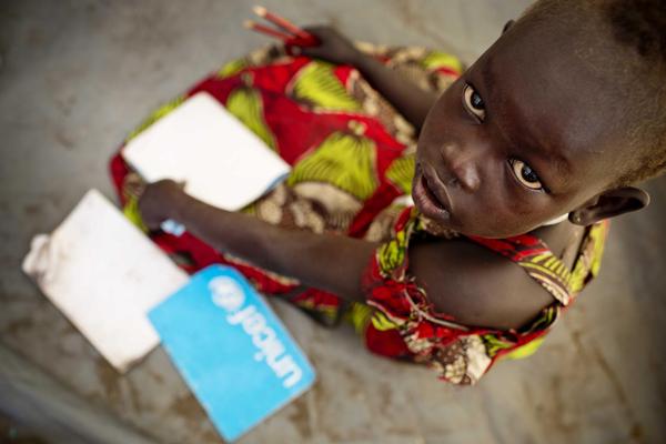 ノートや学用品などの支援物資を受け取った戦闘で避難している子ども。（南スーダン）© UNICEF/NYHQ2014-0369/Holt