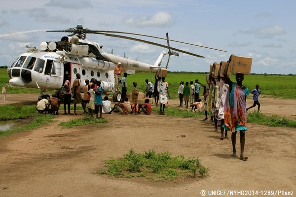 上ナイル州の町Kiech Konにヘリコプターで空輸された食糧などの支援物資を運ぶ女性たち。© UNICEF/NYHQ2014-1289/Pflanz