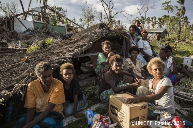 サイクロンで破壊された家の前で座る、バヌアツ・タンナ島の住民たち。©UNICEF Pacific_2015