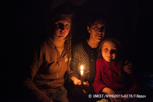 防空壕でろうそくを灯す親子。© UNICEF_NYHQ2015-0278_Filippov