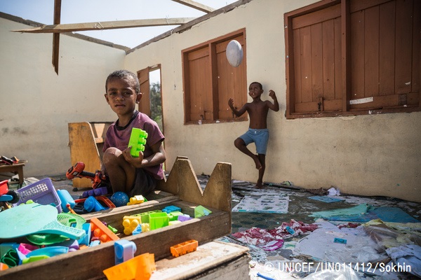 サイクロンで破壊された教室に残されたおもちゃで遊ぶ4歳の子ども。© UNICEF_UN011412_Sokhin