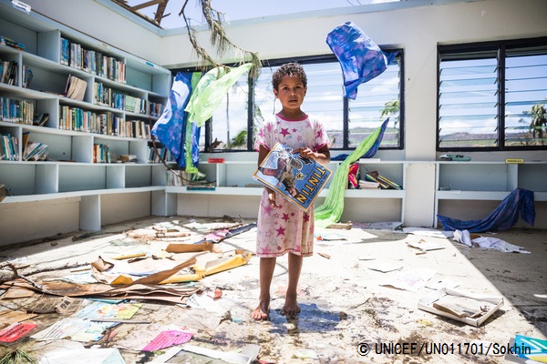 サイクロンの被害にあった小学校の図書館で本を手にたたずむ女の子。© UNICEF_UN011701_Sokhin