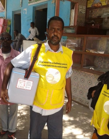 ソマリアでポリオのワクチンを保冷ボックスに入れて移動する男性。ポリオワクチンは熱に弱く、常に一定の温度を保つ必要がある。（ソマリア）　(C) UNICEF/Somalia