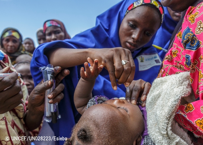ナイジェリアの国内避難民キャンプにてユニセフ職員からポリオの予防接種を受ける子ども（2016年8月撮影）