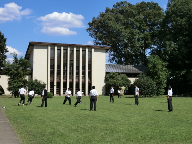 自由学園男子部体育館（東京都選定歴史的建造物）前の芝生で昼食後の休み時間のひとときを過ごす男子部の生徒