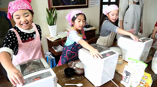 ヌードルメーカーで、青森県南部の郷土料理 「つつけ」作りを体験する子供たち