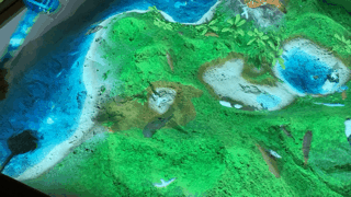 水のステッキをかざすと、砂の上に水があふれ出す