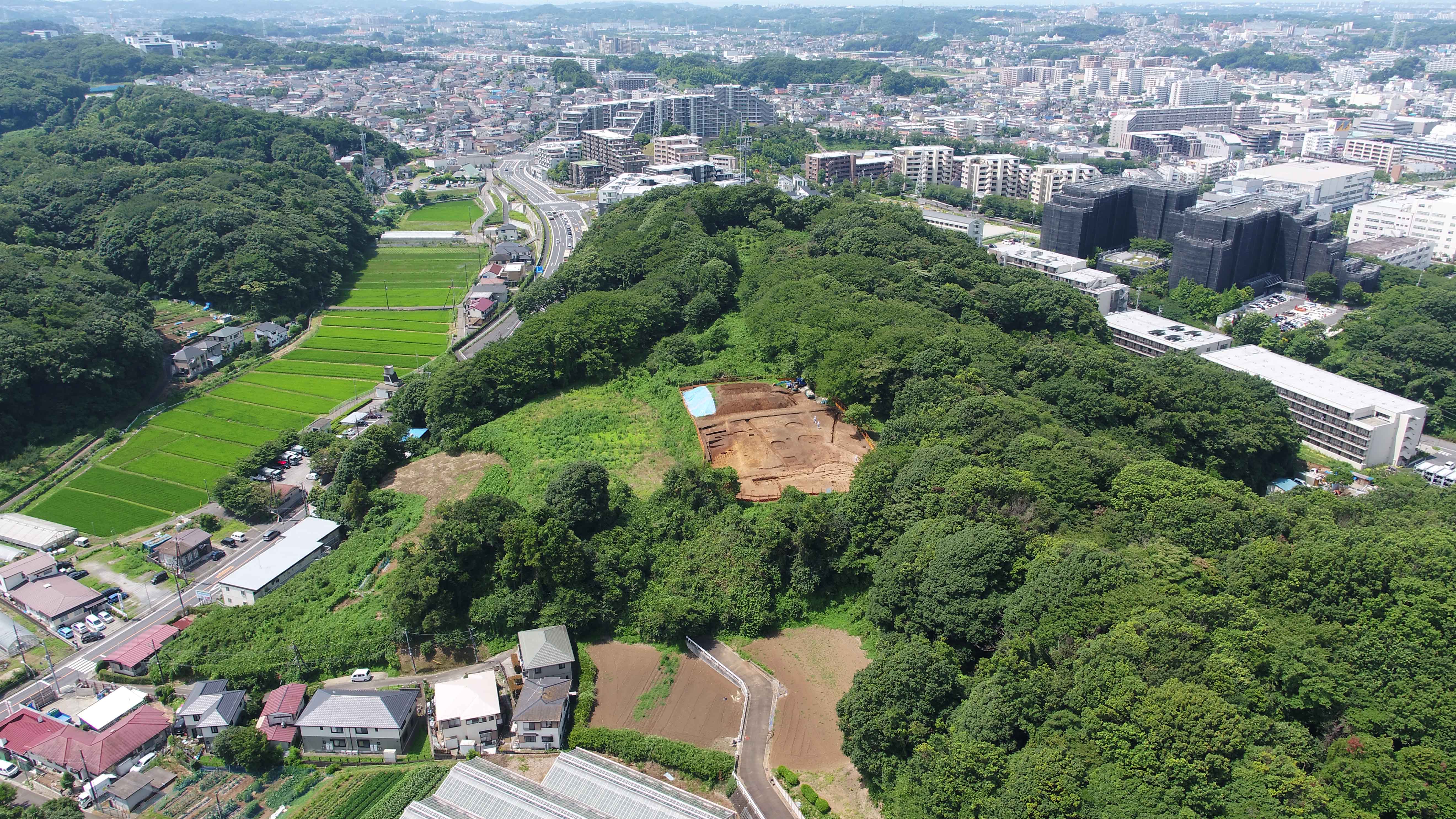 空から見た舞岡熊之堂遺跡と戸塚の街並み（平成30（2018）年、北東から、空撮）