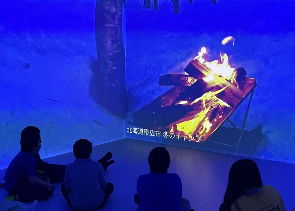 uralaa で再現された十勝の風景・焚火の映像に見入る子ども達