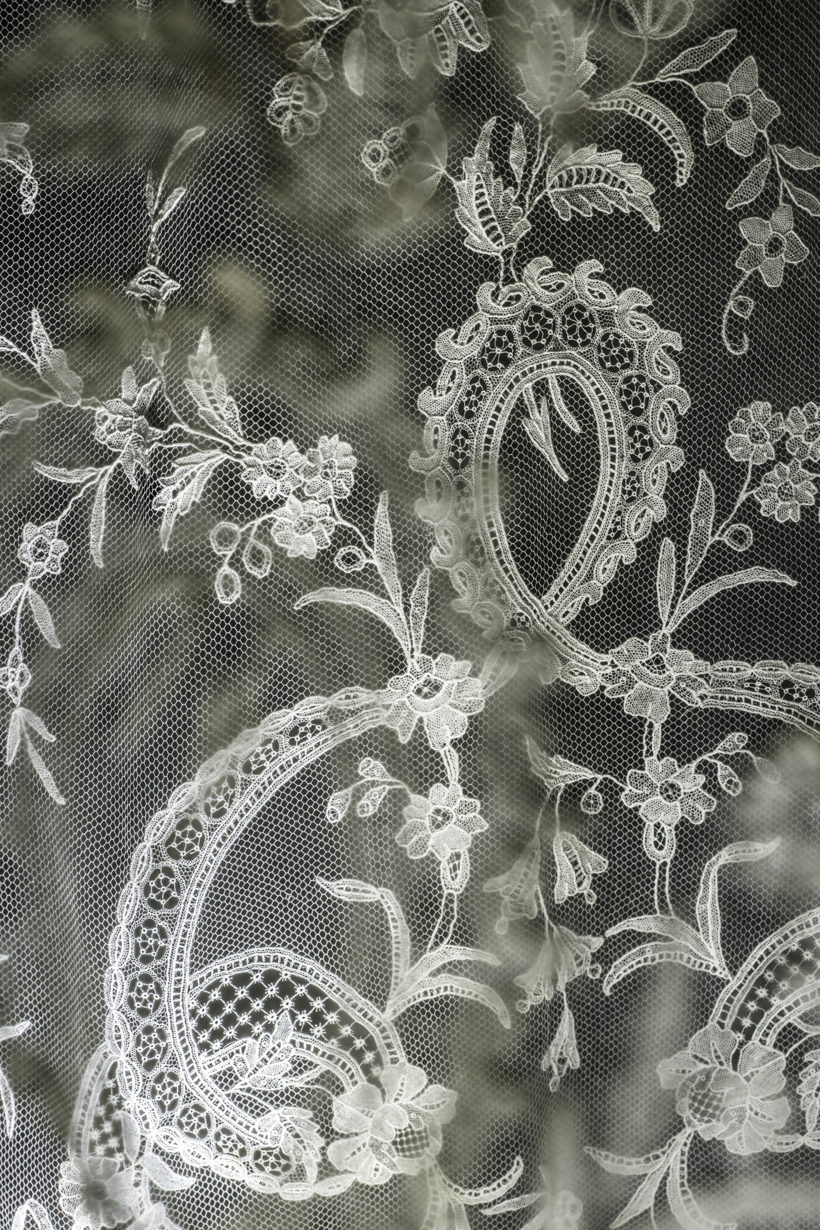 ブリュッセル・アプリケーションレース 手法　ニードルポイント・アプリケーション 産地　ベルギー    制作年　19世紀  機械でつくったネットに、針でつくった繊細なモチーフを手仕事でつなぎ合わせている。ネットにレスーのモチーフを正確にアップリケするのに非常