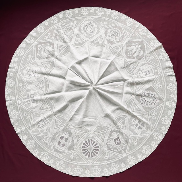 ウォー・レース 手法　ポワン・ド・パリ、ボビンレース 産地　ベルギー 製作年　1914－18年 サイズ　30×130 このテーブルクロスには、第一世界大戦時の連合国や同盟国のメダリオンが飾られている。