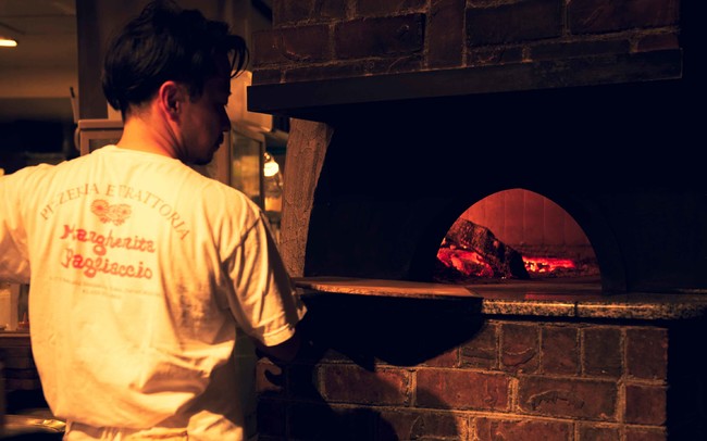 店内の薪窯で焼き上げるピッツァ