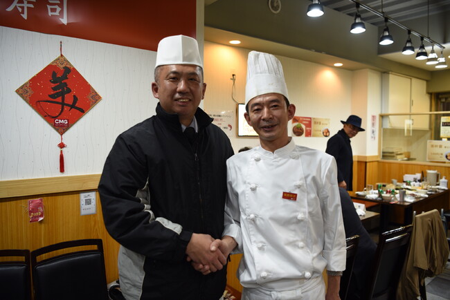 グルメイベント「日本における遼寧の味 ― 遼寧料理を日本の中華レストランへ」に登場した「築地青空三代目」本店の石渡雄一郎氏（左）と、餃子達人の王海峰氏（2022年11月22日撮影）。(c)AFPBB News