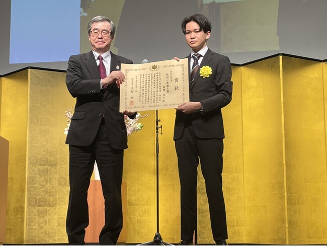 3月13日のパテントコンテスト表彰式において濱野特許庁長官による賞状授与の様子（左：濱野特許庁長官　右：西田悠人）