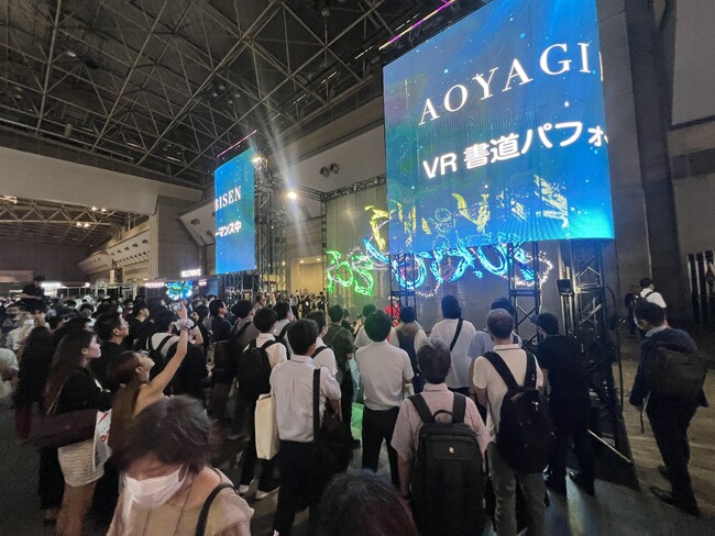 大画面を用いたVR書道ライブイベントは多くの人がカメラを構えて撮影していた