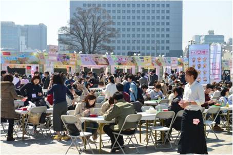 青空の中ラーメンをすする女性達