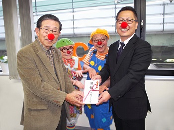 日本クリニクラウン協会理事長　河敬世様（写真左）に目録を贈呈するアイリックコーポレーション取締役副社長　半澤勝広と、クリニクラウン