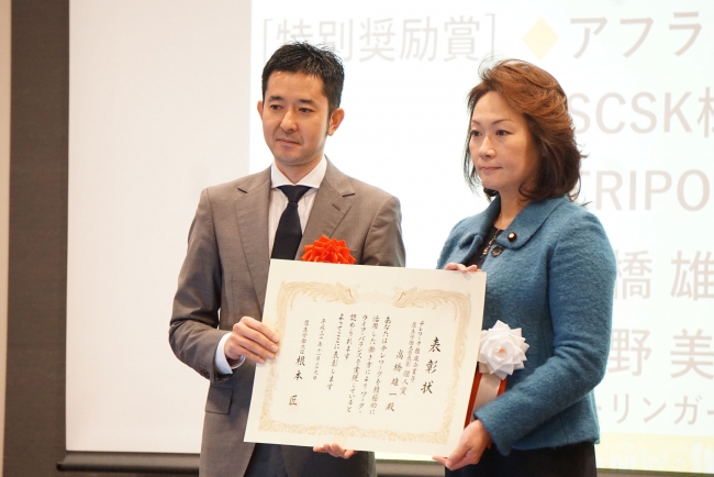 髙階恵美子厚生労働副大臣（右）、「個人賞」を受賞した高橋雄一（左）