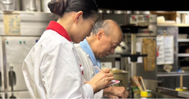 「いい？これはね…」と谷口さんが話し始めると、すぐにメモを取り、谷口さんの手元を見つめるシャンイエさん