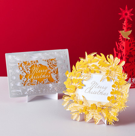 繊細な切り絵で描かれた、クリスマスの世界観。 ｢nekonekodesign PAPER ARTS」 (左)二つ折りクリスマスカード (1枚)935円、 (右)リース型クリスマスカード 935円