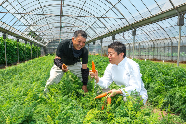 海老原ファームにて。生産者の方と食材を確認する統括料理長 太田高広