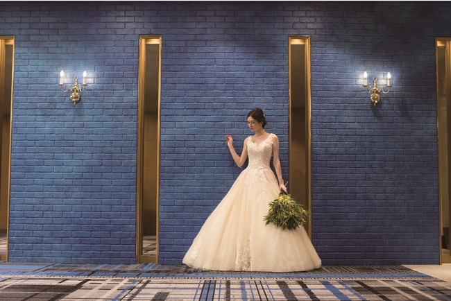 花嫁に幸せをもたらす”サムシングブルー”の壁の前で