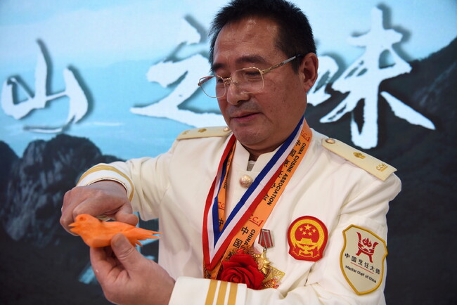 グルメイベント「日本における遼寧の味」の開幕式で、野菜の彫刻を披露する王建華氏。東京都内で(2022年11月18日撮影)。(c)AFPBB News グルメイベント「日本における遼寧の味」の開幕式で、野菜の彫刻を披露する王建華氏。東京都内で(2022年11月18日撮影)。(c)AFPBB News