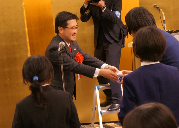 イーブックイニシアティブジャパン社長 小出から記念品を贈呈される藤戸さん