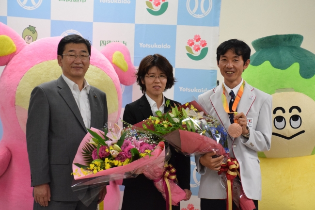 左から佐渡市長、妻の歩美さん、岡村正広選手