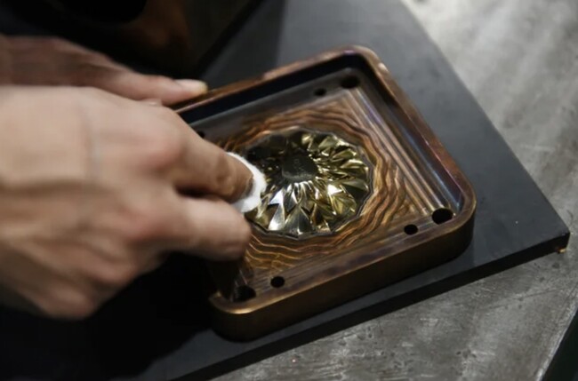 画像の説明：シリコーングラスをつくる金型を磨き上げている様子