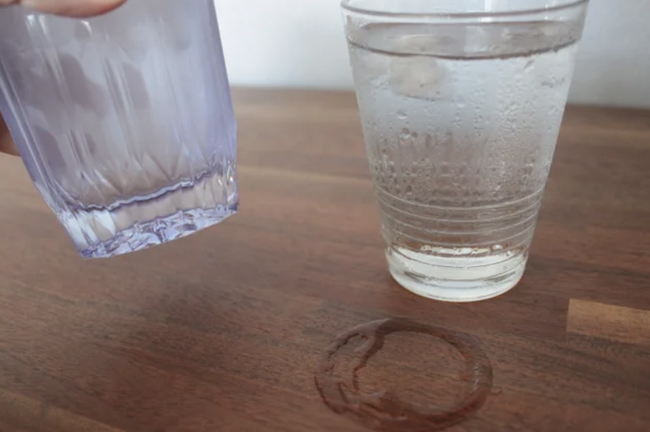 画像の説明：結露していないKINJO JAPANのシリコーングラスを持ち上げ、右側には水滴がテーブルについた、結露したガラスのグラスが右に置かれた様子