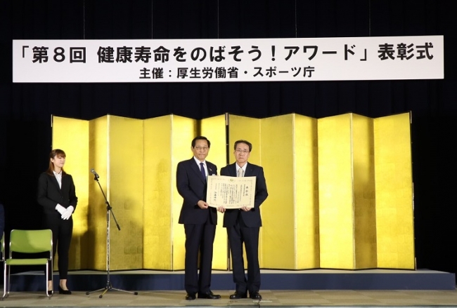 写真左：厚生労働大臣政務官 小島敏文氏、写真右：公社常務理事 西谷一彦
