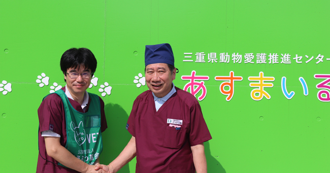 三重県どうぶつ愛護センター「あすまいる」前で握手する久米センター長とどうぶつ基金顧問山口獣医