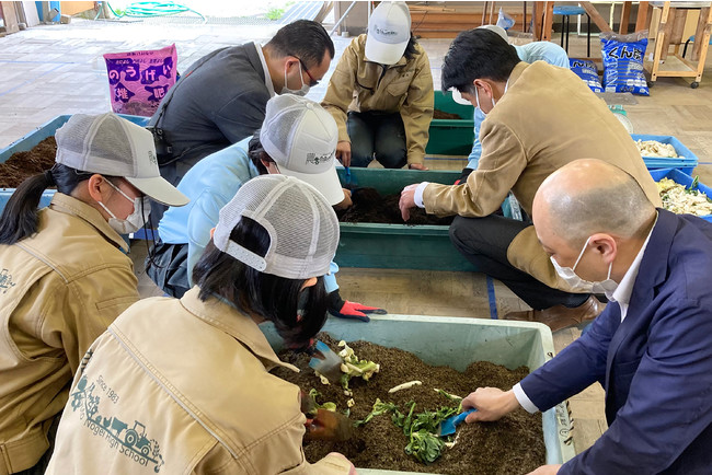 農芸校生から堆肥作りのレクチャーを受けるホテルスタッフ