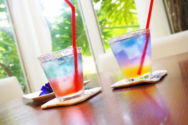 garden kuu cafe「Rainbow Tea ヲナリブ レンド」 琉球最⾼神⼥「聞得⼤君」の紺碧の⾐装からイメ ージした⻘いハーブティー。ハイビスカスまたは シークワーサーをブレンドにして。⻘の源は南城 市の⼥性たちが育てた天然ハーブの蝶⾖。