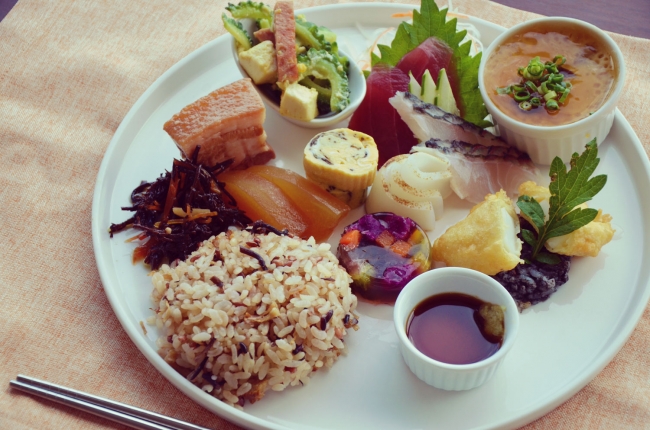 Cafe やぶさち「古代米プレート」 稲作発祥伝説にちなみ希少な南城産古代⽶を 「じゅうしぃ」に。絶景カフェで沖縄料理の定 番をワンプレートで。