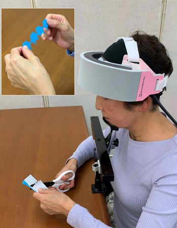 切り紙をしている60代女性の脳を「fNIRS脳機能計測装置」で計測